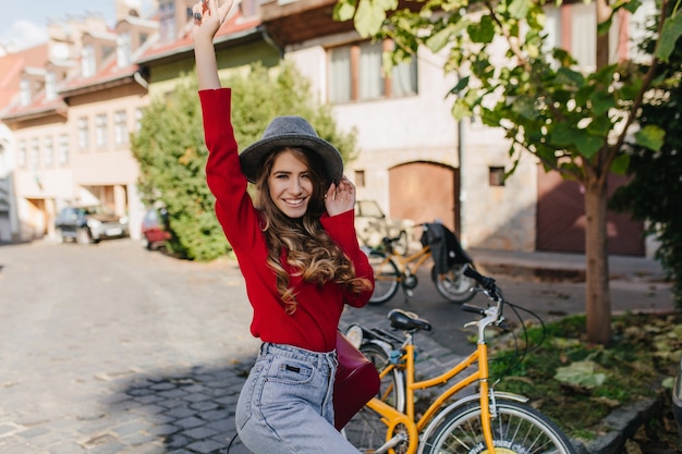 Jolie dame caucasienne exprimant des émotions drôles lors d'une balade à vélo autour de la ville d'automne