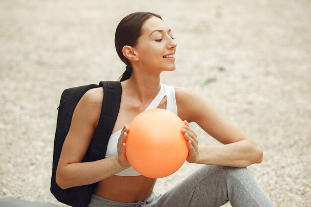 Jolie dame s'entraînant sur une plage d'été. Brunette faisant du yoga. Fille en tenue de sport.