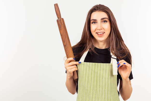 Une jolie dame tenant un rouleau à pâtisserie et à la caméra