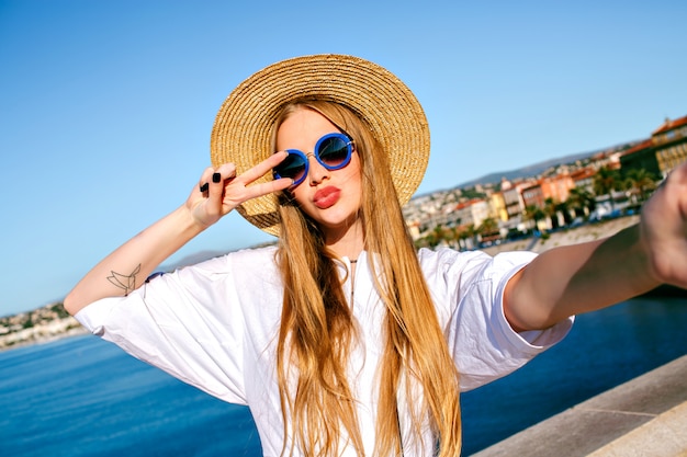Jolie élégante blonde belle femme faisant selfie devant sur la plage de Nice