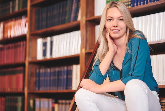 Jolie étudiante relaxante dans la bibliothèque