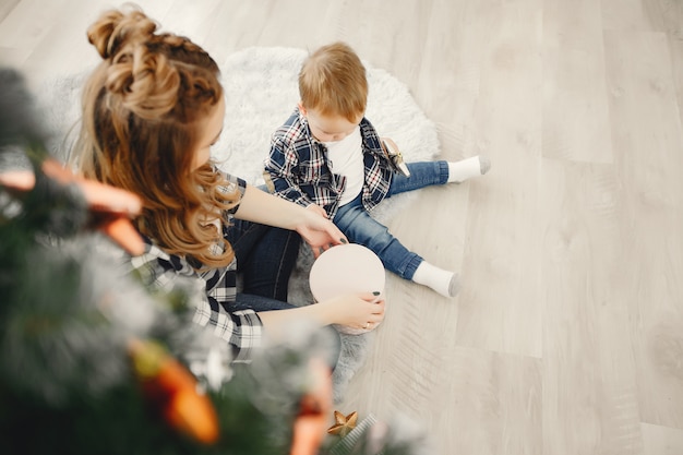 Jolie famille assis près d&#39;un arbre de Noël