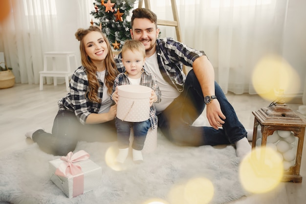 Jolie famille assis près d&#39;un arbre de Noël