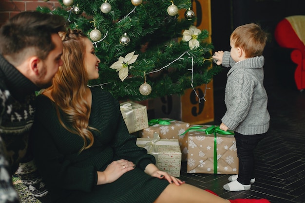 Jolie famille assis près d&#39;un arbre de Noël