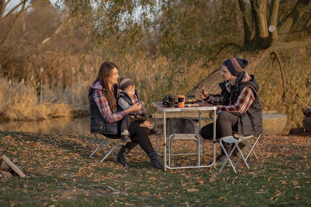 Jolie famille assise sur un pique-nique dans une forêt