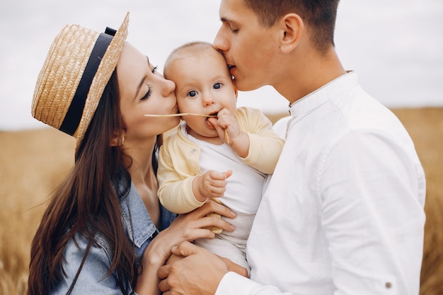 Photo gratuite jolie famille jouant dans un champ d'automne