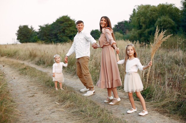 Jolie famille jouant dans un champ d'automne