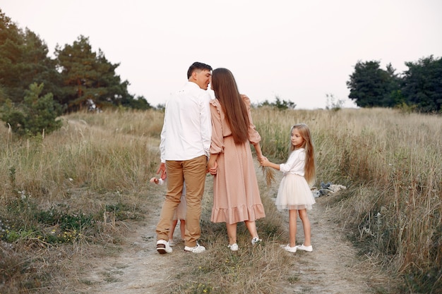 Jolie famille jouant dans un champ d'automne