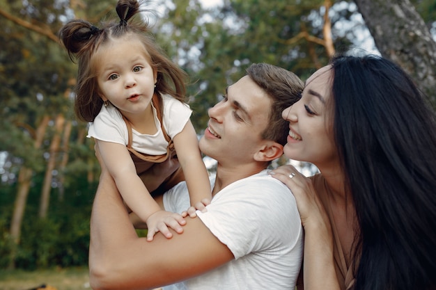 Jolie famille jouant dans un champ d'automne