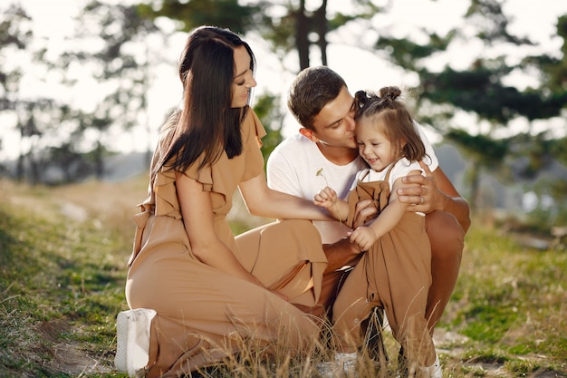 Jolie famille jouant dans un champ d'automne