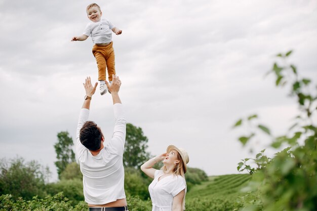 Jolie famille jouant dans un champ d'été