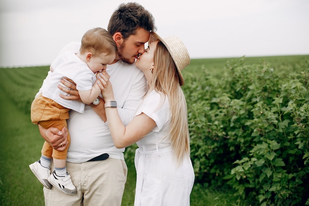 Jolie famille jouant dans un champ d'été