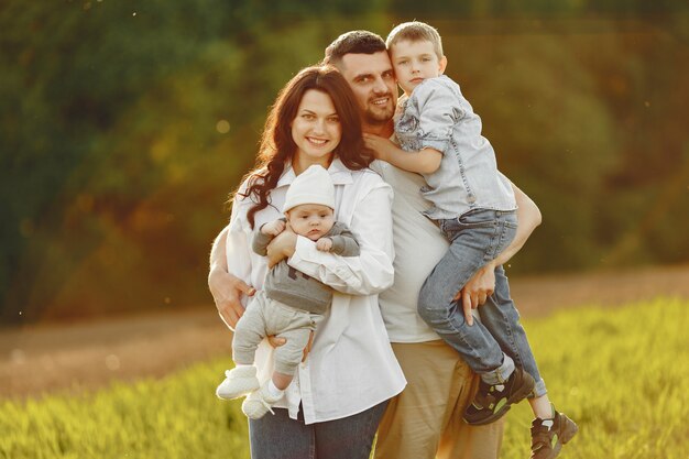 Jolie famille jouant dans un champ d'été