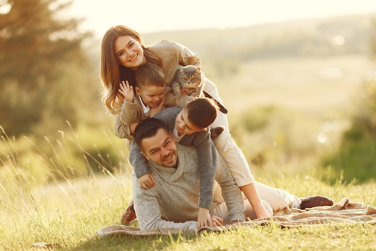 Photo gratuit une jolie famille jouant dans un champ d'été.
