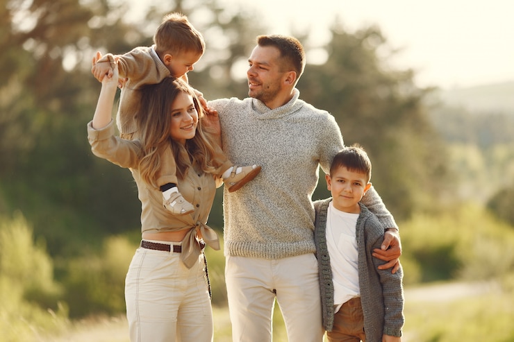 Photo gratuit une jolie famille jouant dans un champ d'été.