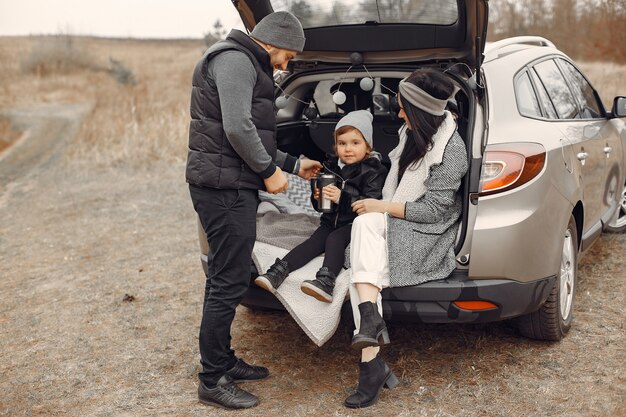 Jolie famille prenant une boisson chaude dans un champ d'hiver