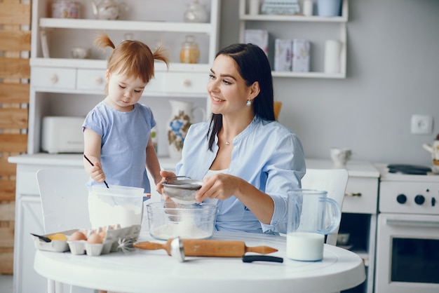 Jolie famille prépare le petit déjeuner dans une cuisine