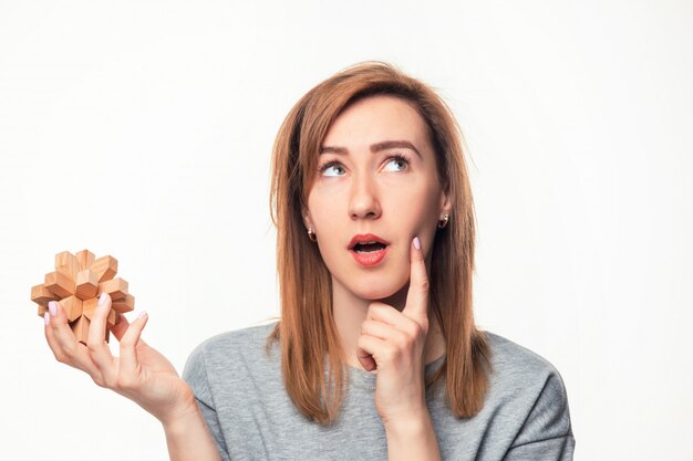 Jolie femme d'affaires de 24 ans à la confusion avec un puzzle en bois.