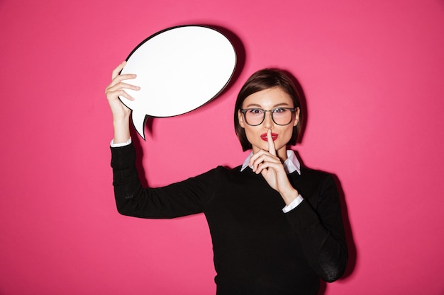 Photo gratuite jolie femme d'affaires détenant une bulle de dialogue et montrant une bulle de dialogue isolée