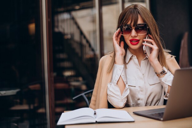 Jolie femme d'affaires travaillant sur ordinateur dans un café