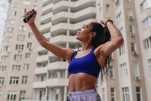 Jolie femme afro-américaine noire en tenue de sport sur le toit faisant de l'exercice