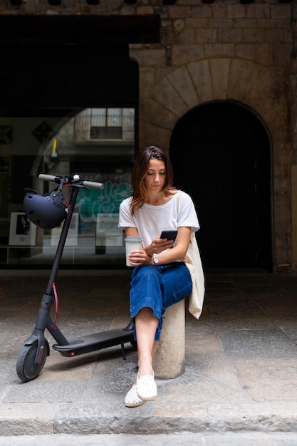 Photo gratuite jolie femme à l'aide d'un scooter écologique