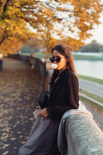 Jolie femme à l'aide de smartphone en plein air dans le parc