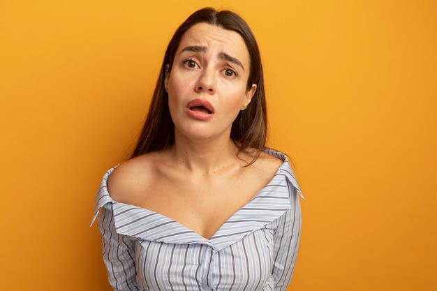 Photo gratuite jolie femme anxieuse regarde à l'avant isolé sur mur orange