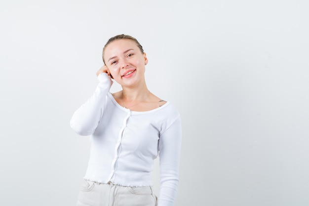 Jolie femme appelle quelqu'un au téléphone sur fond blanc