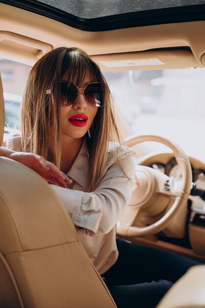 Jolie femme assise dans sa voiture