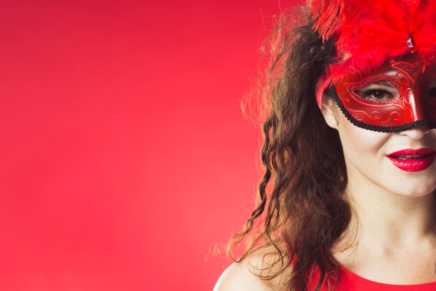 Jolie femme au masque de carnaval rouge