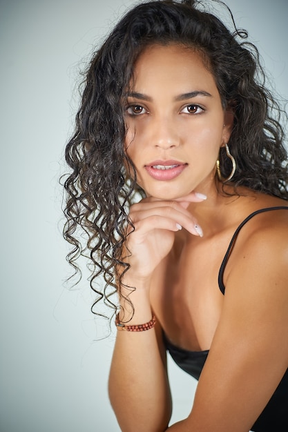 Jolie femme aux cheveux bouclés pose devant la caméra