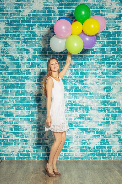 Jolie femme avec des ballons colorés