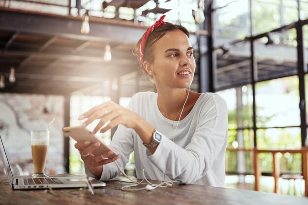 Jolie femme blonde assise dans un café