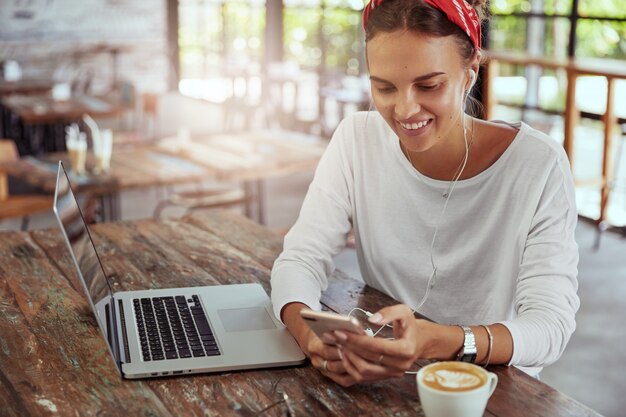 Jolie femme blonde assise dans un café