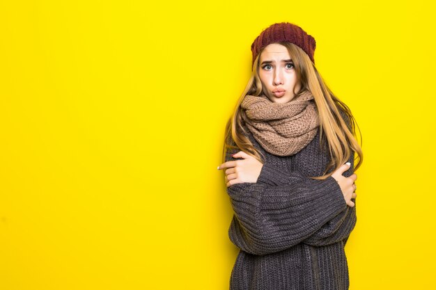 Jolie femme blonde en pull chaud essaie de se réchauffer