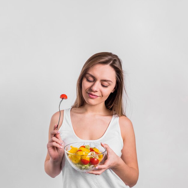 Jolie femme avec bol de salade et fourchette