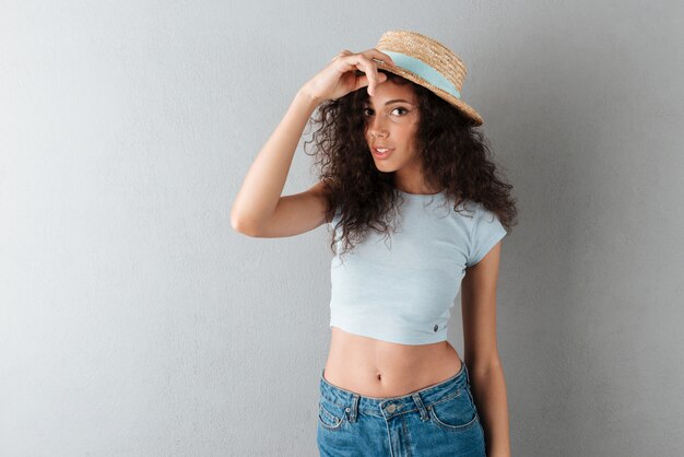 Jolie femme bouclée au chapeau