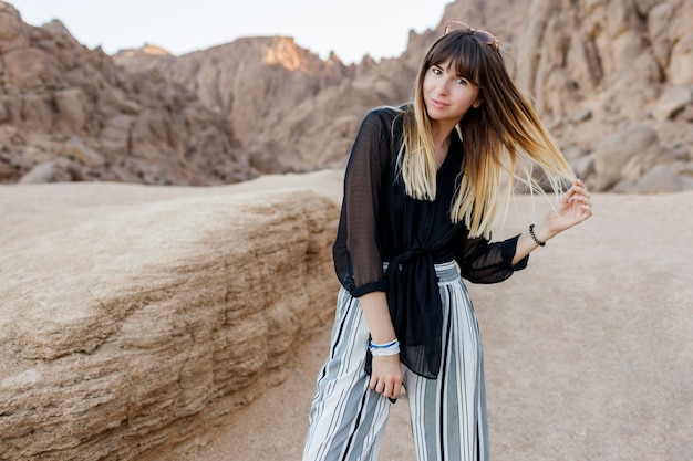 Photo gratuite jolie femme brune posant dans les dunes de sable du désert égyptien.