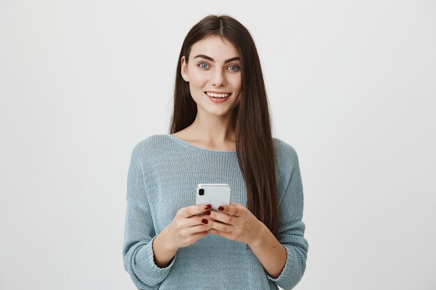 Jolie femme caucasienne à l'aide de smartphone