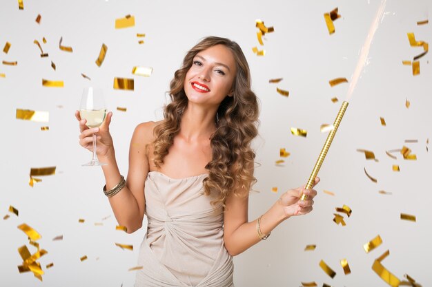 Jolie femme célébrant le nouvel an en confettis dorés