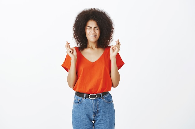 Jolie femme avec une coiffure afro posant en studio