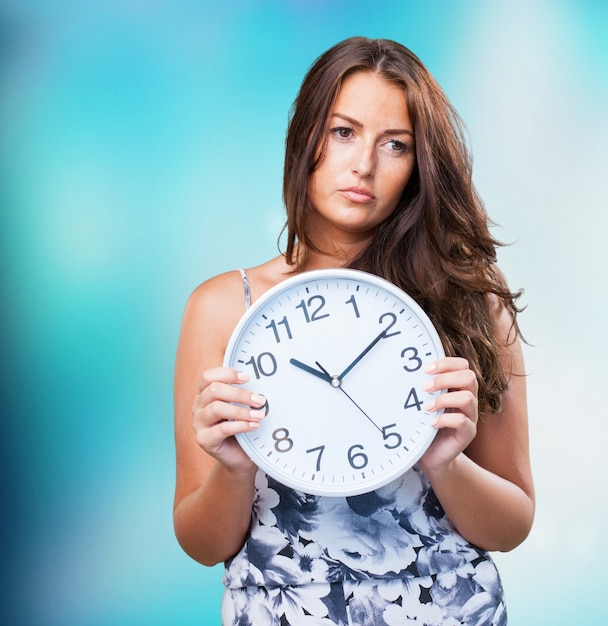 jolie femme en colère tenant une horloge