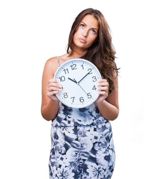 jolie femme en colère tenant une horloge