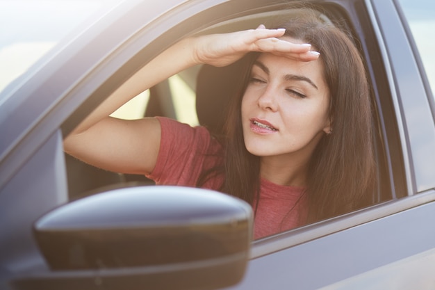 Jolie femme concentrée garde la main sur le front