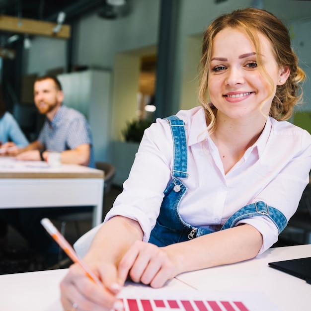 Jolie femme corrigeant le graphique et posant