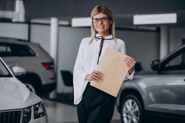 Jolie femme dans une salle d'exposition de voiture