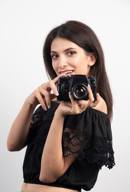 Jolie femme debout avec un appareil photo