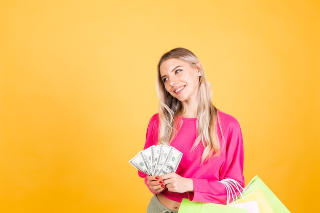 Jolie femme européenne en chemisier rose sur mur jaune