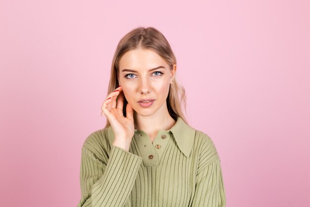 Jolie femme européenne en pull décontracté sur mur rose